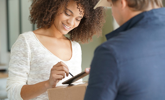woman signing after recieving a package