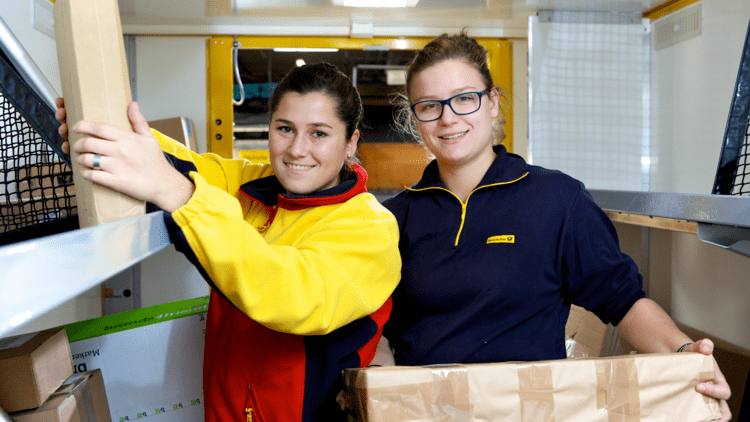two dhl women employees holding boxes