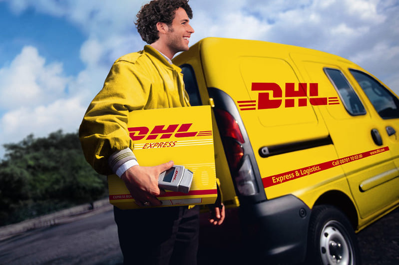 dhl man with box and dhl truck at the back